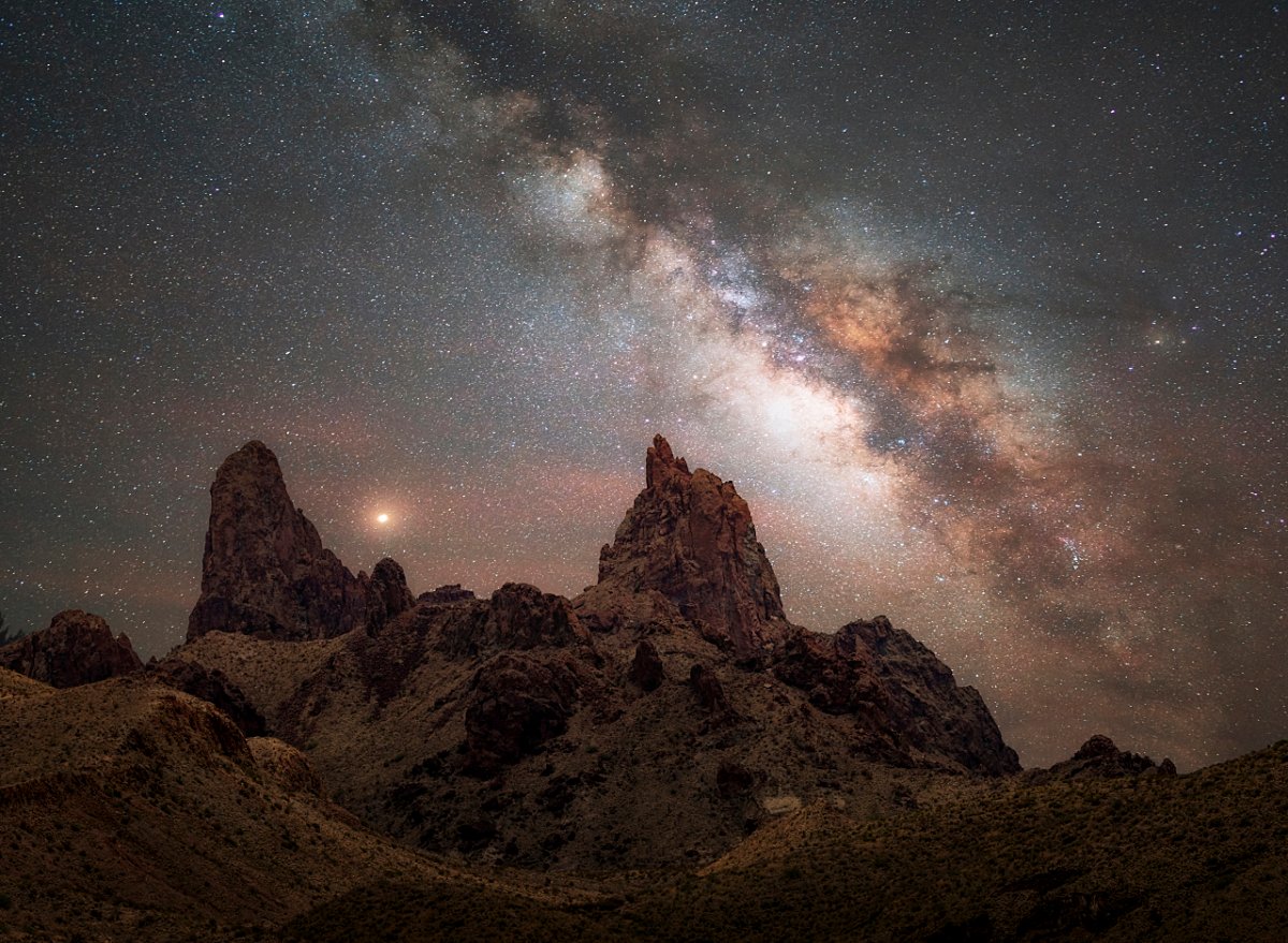 A panel Tryptich of stunning photo of the Milky Way galaxy over a desert landscape, with two rock formations resembling mule ears in the foreground. The night sky is filled with stars and nebulae, creating a contrast with the dark silhouette of the rocks and plants. The photo showcases the beauty and mystery of the cosmos, as well as the skill and creativity of Andy Morgan Photography.