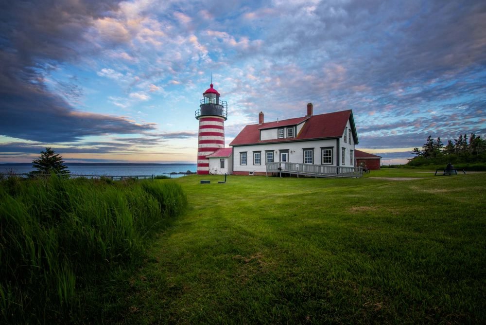 Bright Red & White Lighthouse at Quoddy Head State Park Maine under a beautiful sunset