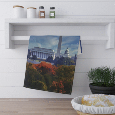 Washington D.C. skyline featuring the Washington Monument, Lincoln Memorial, and the U.S. Capitol Building, with colorful autumn foliage in the foreground.