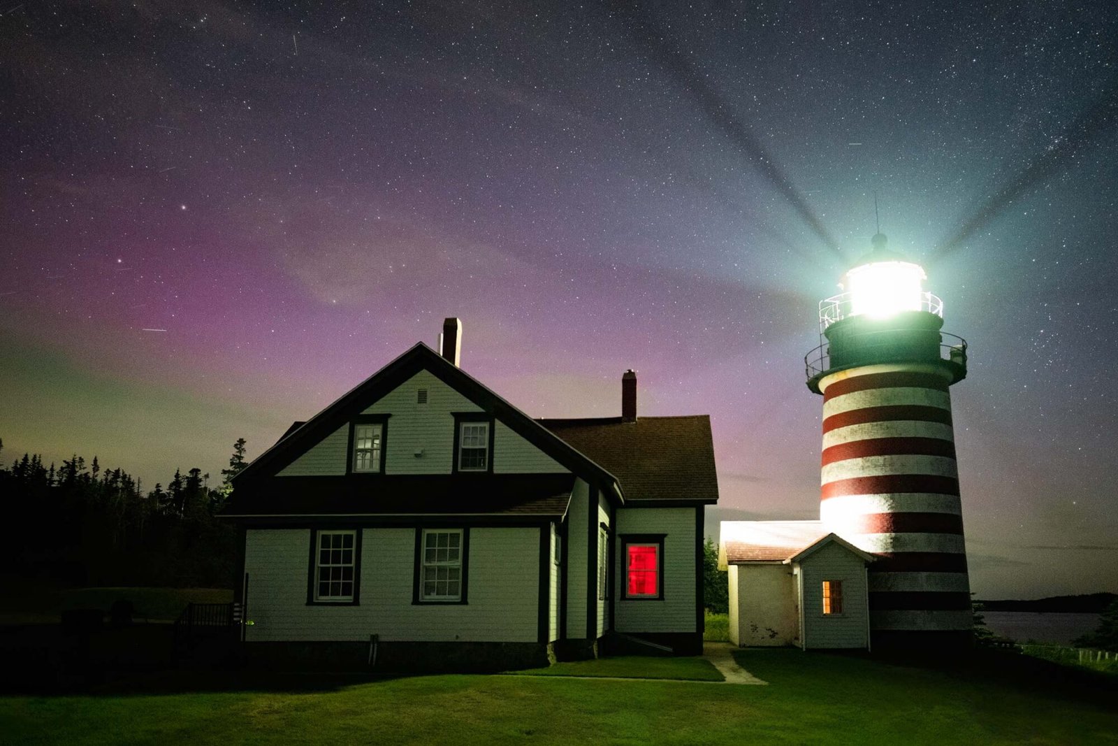 West Quoddy Light in Lubec, Maine, under a starry sky with subtle northern lights visible, photographed in September 2024.