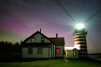 West Quoddy Light in Lubec, Maine, under a starry sky with subtle northern lights visible, photographed in September 2024.