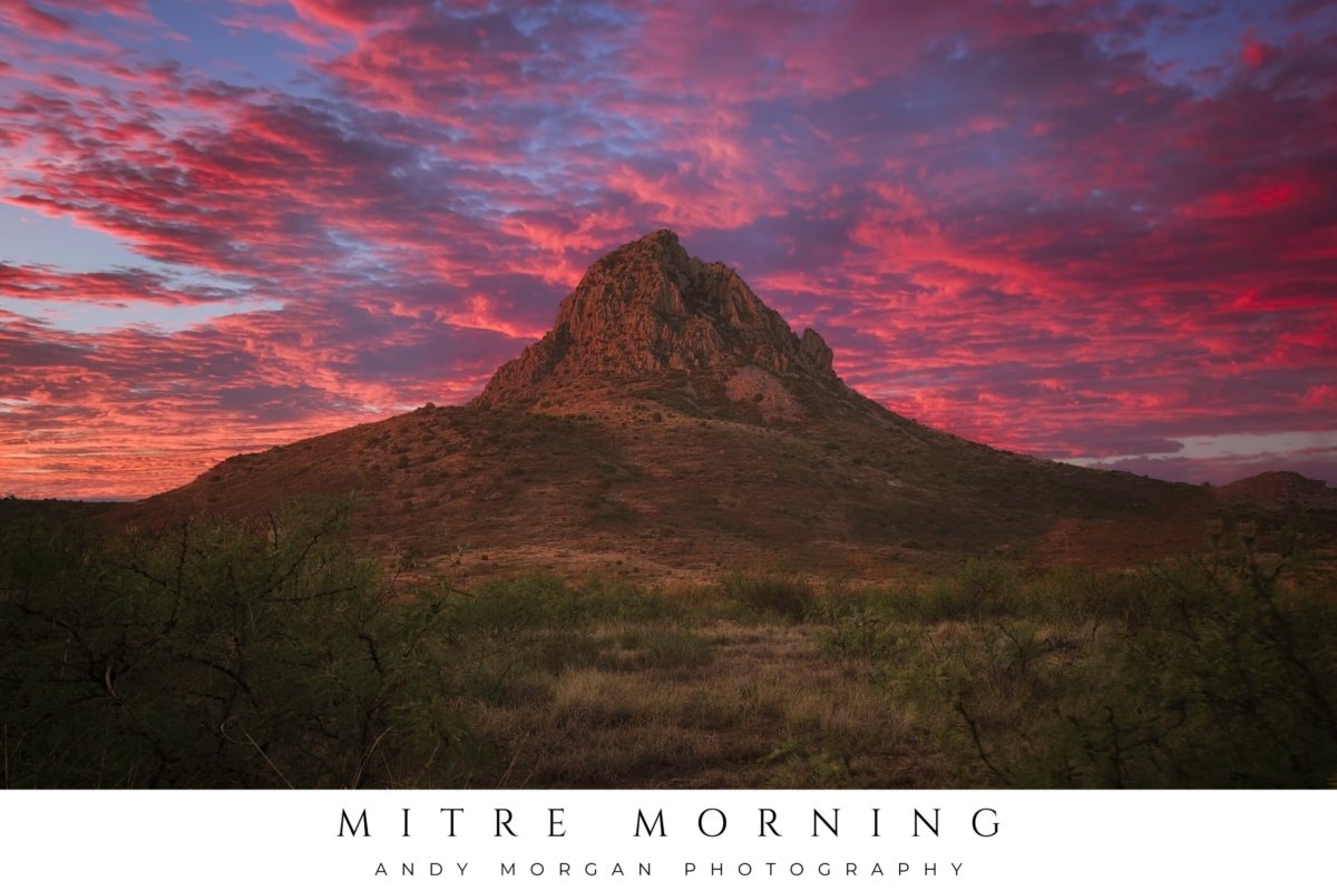 Poster showing Mitre Peak near Alpine, Texas, illuminated by a vibrant red and purple sunrise sky with dramatic clouds overhead.