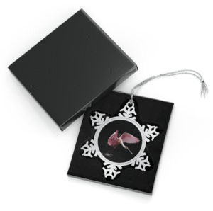 A snowflake-shaped pewter ornament featuring a close-up photograph of a roseate spoonbill in flight, surrounded by a silver frame.