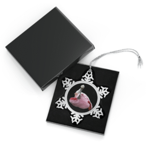 A snowflake-shaped pewter ornament featuring a close-up photograph of a roseate spoonbill with its head tucked back, surrounded by a silver frame.