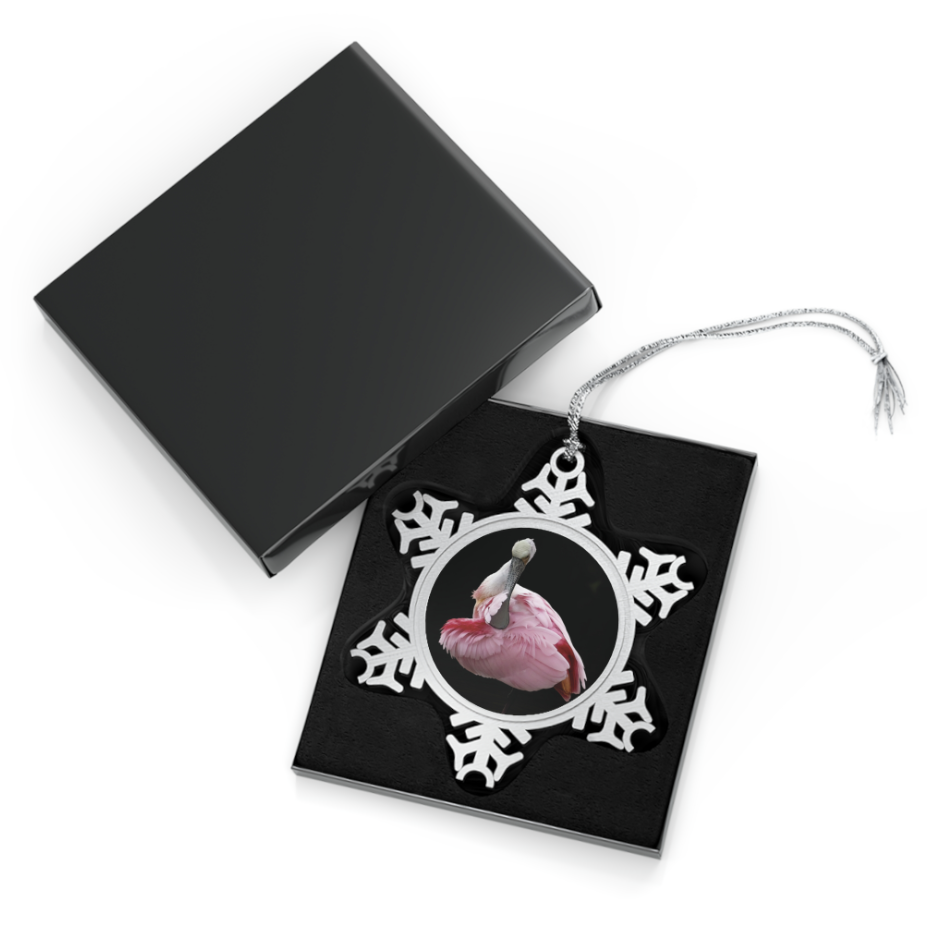 A snowflake-shaped pewter ornament featuring a close-up photograph of a roseate spoonbill with its head tucked back, surrounded by a silver frame.