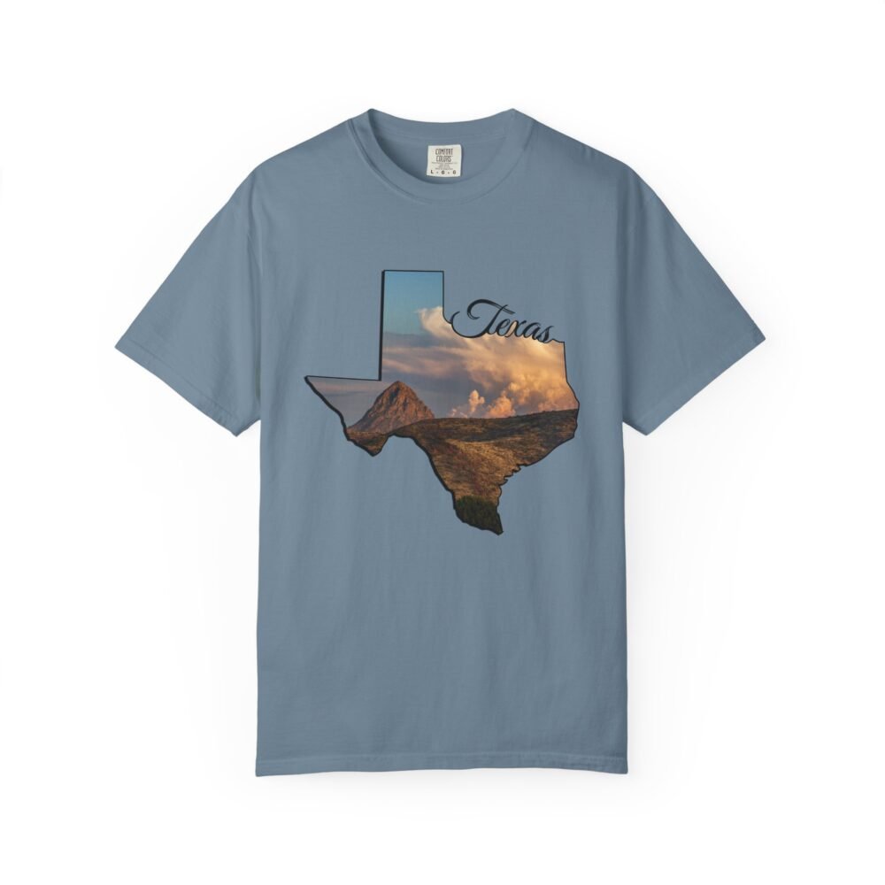 Blue t-shirt with Texas state map outline filled with a landscape photo of mountains, desert, and dramatic sky, with "Texas" script.