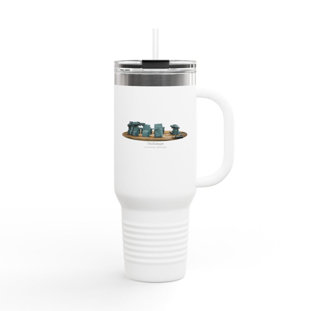 A white insulated travel tumbler with a clear lid and straw, featuring a graphic of Carhenge, a replica of Stonehenge made from vintage gray cars, with text reading "CARHENGE ALLIANCE, NEBRASKA."