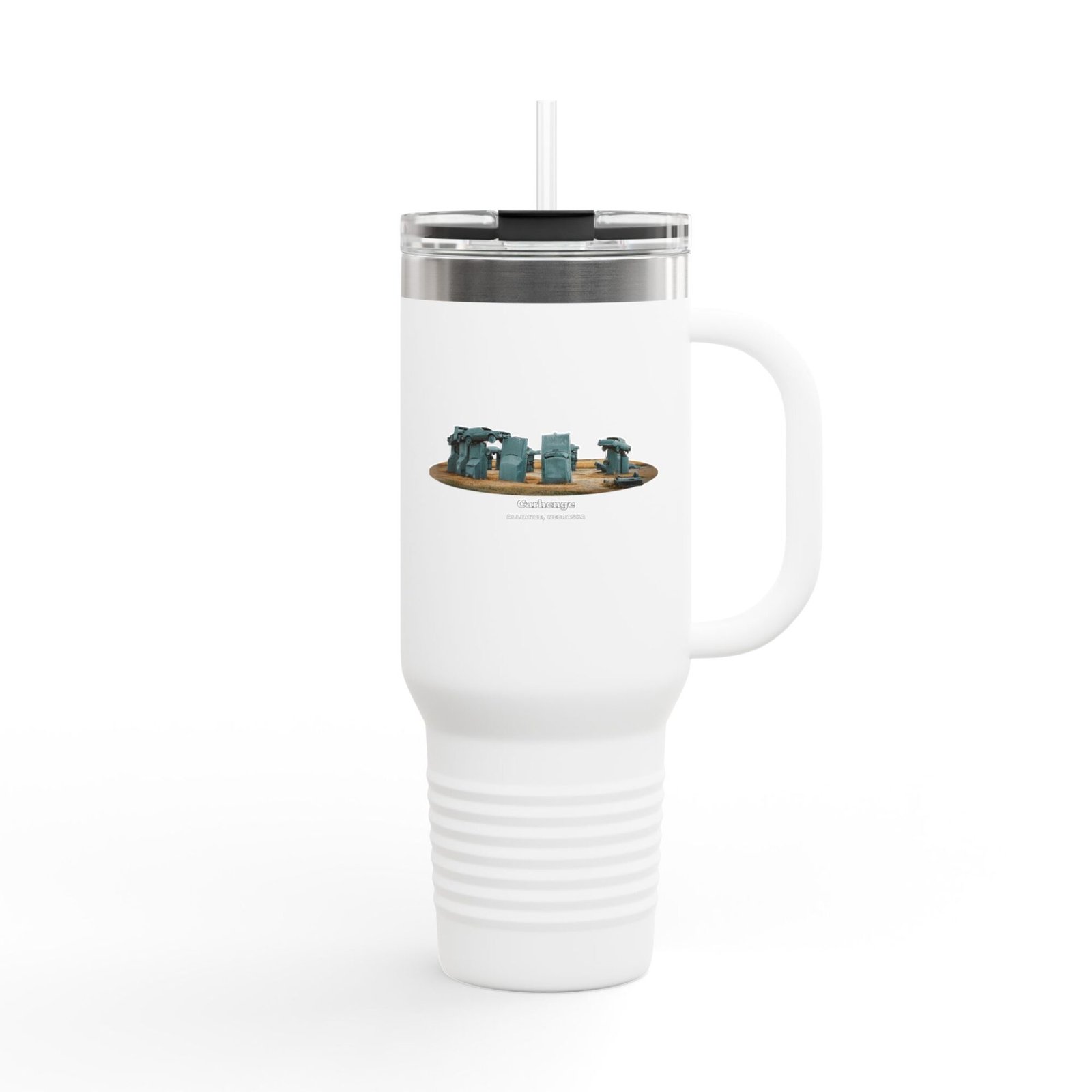 A white insulated travel tumbler with a clear lid and straw, featuring a graphic of Carhenge, a replica of Stonehenge made from vintage gray cars, with text reading "CARHENGE ALLIANCE, NEBRASKA."