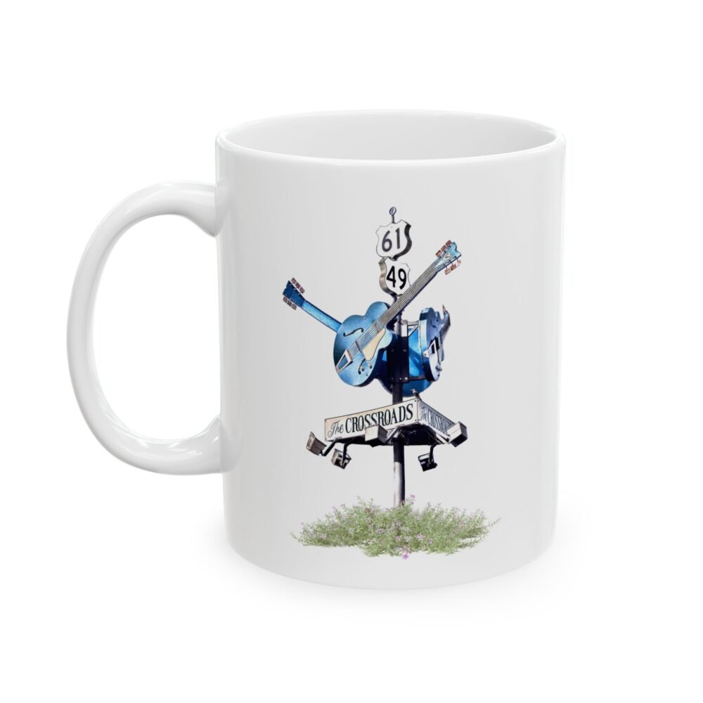 White ceramic coffee mug featuring a blues crossroads sign with a blue guitar and "THE CROSSROADS" text.