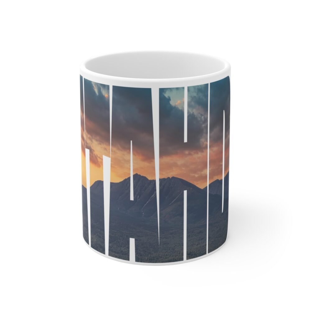 White ceramic coffee mug featuring the word "KATAHDIN" with a sunset mountain landscape inside the letters.