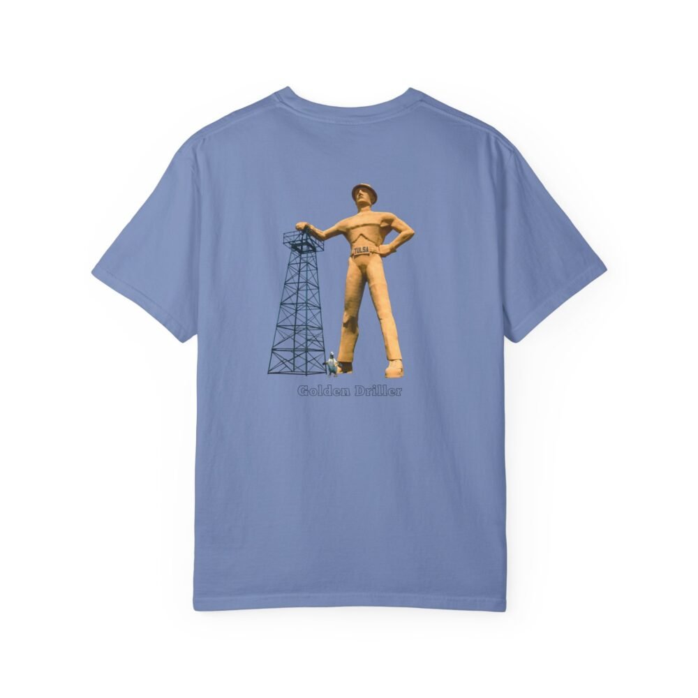 A light green t-shirt with a graphic of the "Golden Driller," a large oil worker statue, standing next to an oil derrick, with text that reads "Golden Driller TULSA, OKLAHOMA."