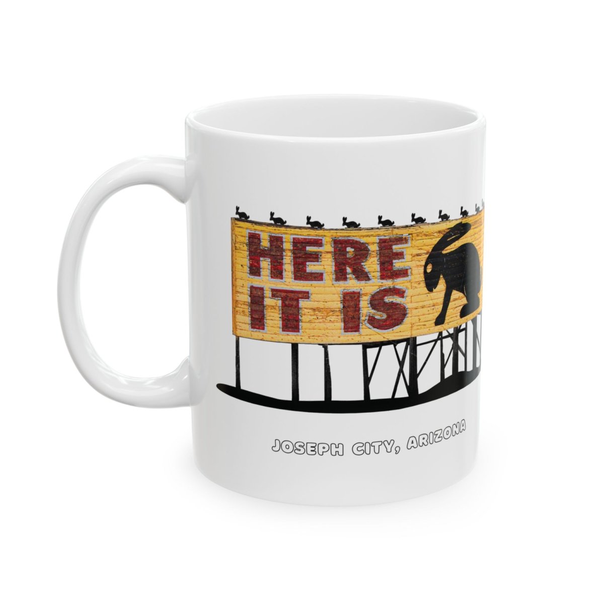 White ceramic coffee mug featuring the "HERE IT IS" jackalope sign from Joseph City, Arizona.