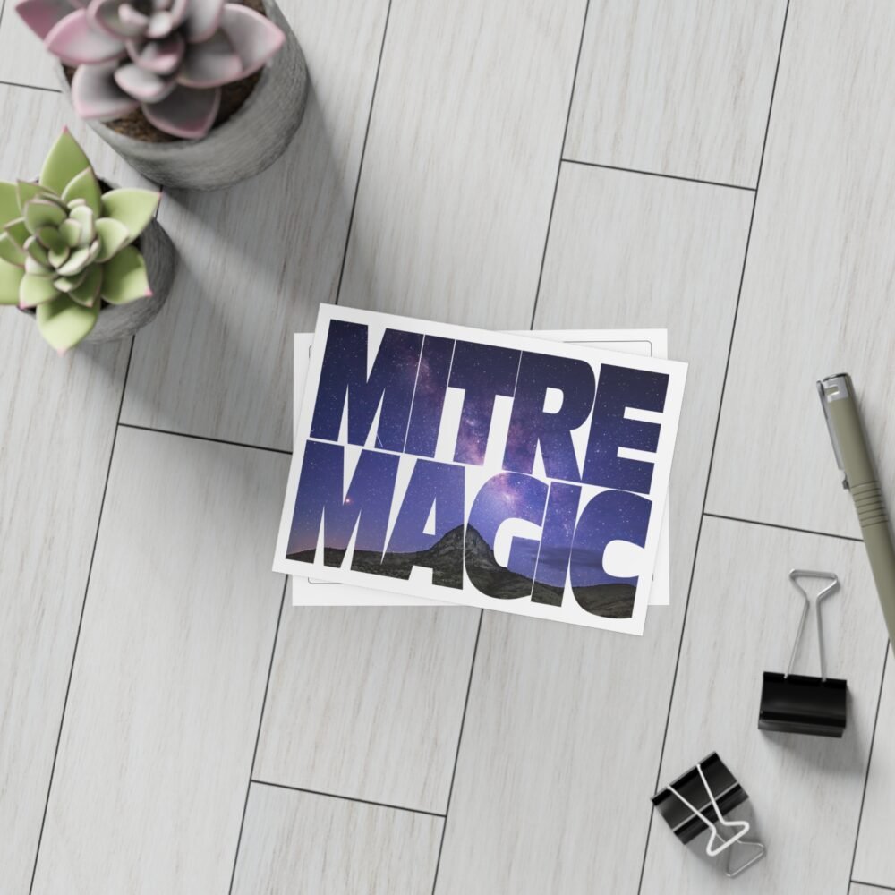 Stack of postcards with "MITRE MAGIC" text over a starry night sky and mountains.