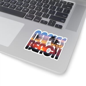 Laptop with a Naples Beach sticker on the lid, featuring palm trees at sunset within the text "NAPLES BEACH."