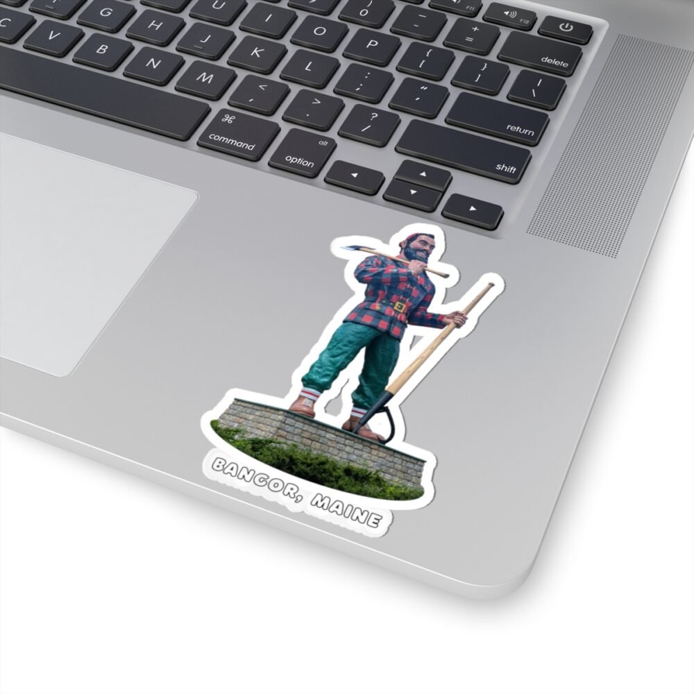 A kiss-cut sticker on a laptop, featuring the Paul Bunyan statue from Bangor, Maine, holding an axe and peavey, with "BANGOR, MAINE" text.