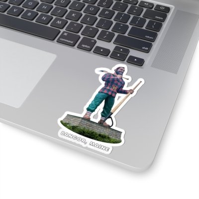 A kiss-cut sticker on a laptop, featuring the Paul Bunyan statue from Bangor, Maine, holding an axe and peavey, with "BANGOR, MAINE" text.