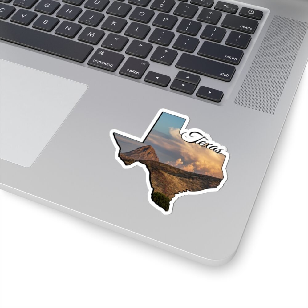 Laptop with a Texas-shaped sticker featuring a mountain landscape and "Texas" text.