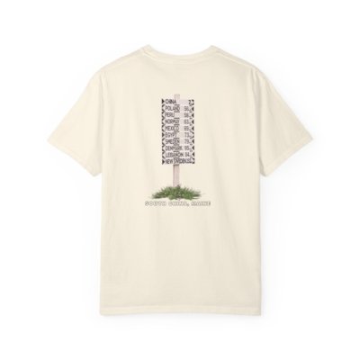 A dark t-shirt shows a vintage-style signpost. Its arms point to distant cities like London, Paris, Tokyo, and more.