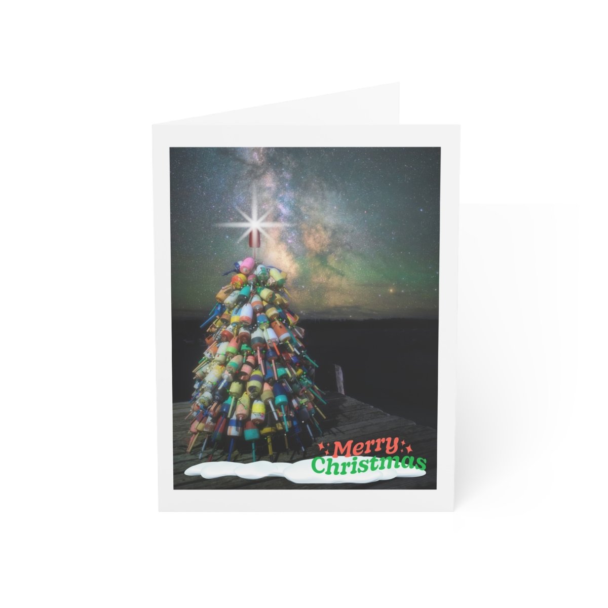 Christmas notecard featuring a Maine lobster buoy tree decorated with a star, set on a dark dock under a starry night sky with Santa's sleigh silhouette. Green text reads "Merry Christmas."